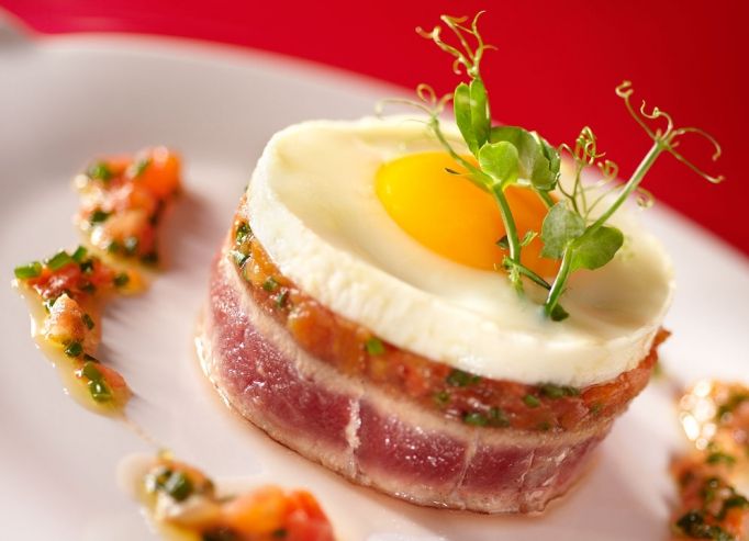 L’œuf à cheval sur un tournedos de thon, tomates confites à l’orange